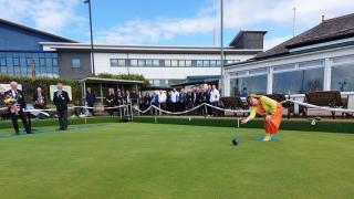 Helena McGowan throwing the first bowl as Club President John Dickie and Vice President George Gilmour, along with the members look on.