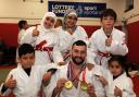 Scott Cusack shows his medals to the young judo stars