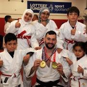 Scott Cusack shows his medals to the young judo stars