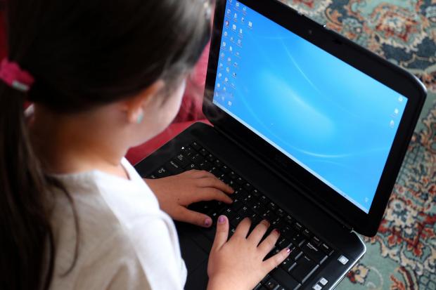 File photo dated 21/08/14 of a child using a laptop computer. Time spent online and mobile phone ownership have increased among children during lockdown as many search for new ways to communicate and be entertained, new research suggests. Issue date: