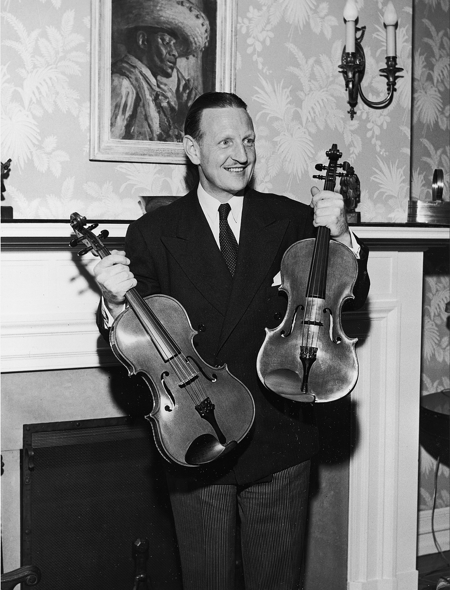 William Primrose holds two violins made for him by William Moennig Jr. in Philadelphia in April 1950. (AP Photo)