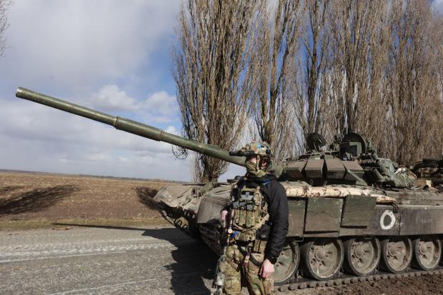 A Ukrainian serviceman stands next to a tank in a village of Lukyanivka, Kyiv region, Ukraine, Monday March 27, 2022. (AP Photo).